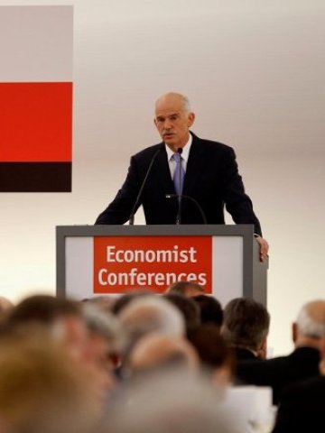 <p style="margin-bottom: 0cm">
	<span lang="bg-BG">Гръцкият премиер Георгиос Папандреу поздравява участниците в икономическа конференция, организирана от </span><span lang="de-DE">Economist. </span><em><span lang="bg-BG">Снимка: Ройтерс</span></em></p>
