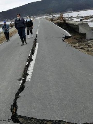 <p>Оцелели&nbsp;след цунамито вървят по разрушен път в префектура Мияги. <i>Снимка: БТА</i></p>