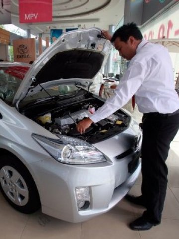 <p>
	Потенциален купувач разглежда Toyota Prius в шоурум на марката в Тайланд. <em>Снимка: Ройтерс</em></p>
