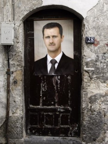 <p>
	Противоречивостта на фигурата на Асад личи дори и по улиците на столицата на Сирия Дамаск. <em>Снимка: Ройтерс</em></p>
