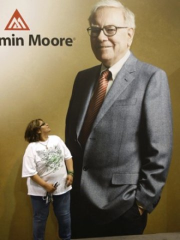 <p>
	Акционер пред плакат на Бъфет на срещата в Омаха. <em>Снимка: Ройтерс</em></p>
