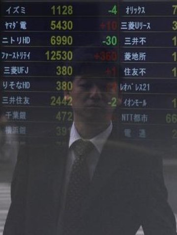 <p>
	Отражение на минувач в електронно табло с котировките на Токийската фондова борса. <em>Снимка: Ройтерс</em></p>
