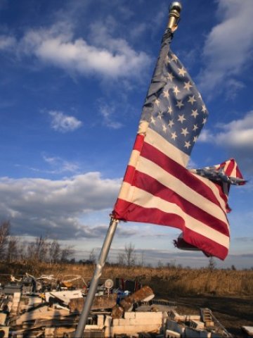 <p>
	Американският флаг се развява над разрушен от урагана Санди дом в Стейтън Айлънд, Ню Йорк. <em>Снимка: Ройтерс</em></p>
