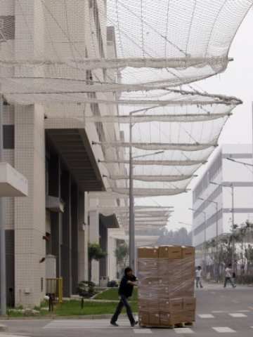 <p>
	Една от фабриките на&nbsp;Foxconn, в които има монтирани мрежи, за да спират &quot;полета&quot; на самоубийците.<em> Снимка: Ройтерс</em></p>
