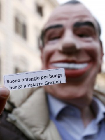 <p>
	Протестиращ срещу политиката на италианското правителство се е предрешил като Берлускони, носейки закачлива покана за &quot;бунга-бунга&quot;. <em>Снимка: Ройтерс&nbsp;</em></p>

