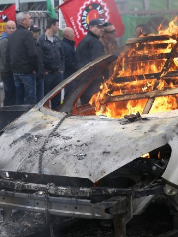 <p>
	Работници във фабриката на Ford в Генк, Белгия, запалиха автомобил на компанията в знак на протест срещу обявените съкращения. <em>Снимка: Ройтерс</em></p>
