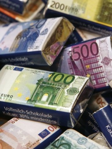 <p style="margin-bottom: 0cm">
	Шоколади с опаковка на евро банкноти на витрината на сладкарница във Виена.<em> Снимка: Ройтерс</em></p>
