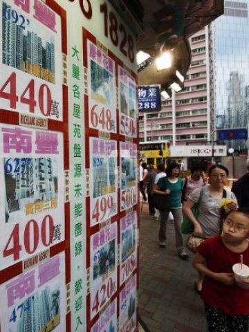 <p style="margin-bottom: 0cm">
	Минувачи пред обяви за продажба на имоти в Хонконг. <em>Снимка: Ройтерс</em></p>
