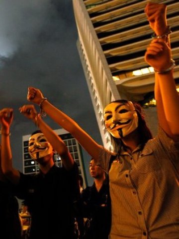 <p>
	Демонстранти с прочутите маски на Anonymous. <em>Снимка: Ройтерс</em></p>
