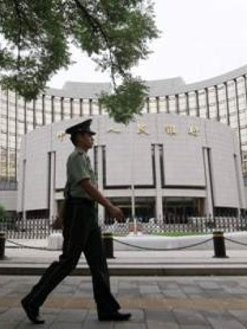<p>Полицай минава покрай сградата на Китайската централна банка в Пекин. <i>Снимка: Ройтерс</i></p>