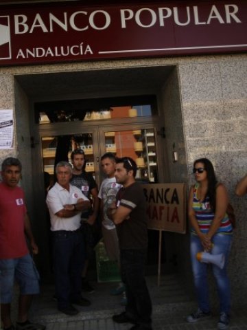 <p>
	<em>Испанци протестират пред клон на Banco Popular с искане за предоговаряне на ипотечните си кредити. Снимка: Ройтерс</em></p>
