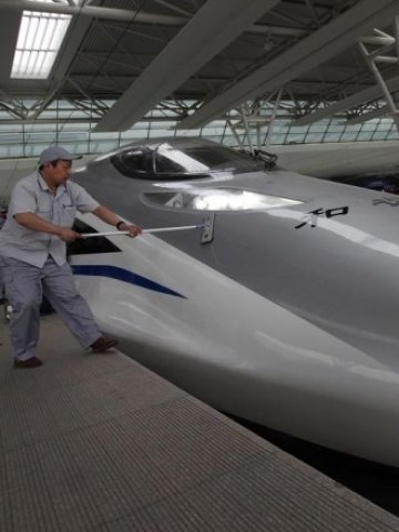 <p>
	Служител почиства влака стрела на гара Хунцяо в Шанхай. Снимка: Ройтерс</p>
