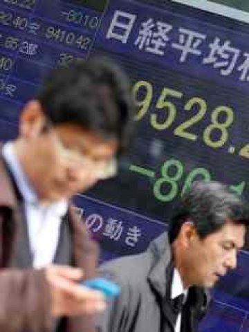 <p>Минувачи преминават покрай дисплей с борсовите индекси в Токио. <i>Снимка: Ройтерс</i></p>