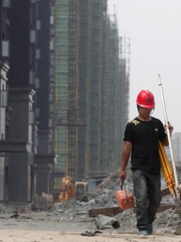 <p>
	Работник на строеж в Шанхай. <em>Снимка: Ройтерс</em></p>

