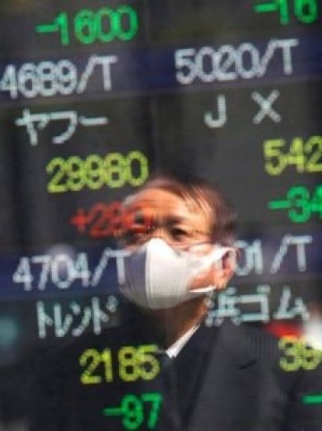 <p>Отражението на минувач с маска в табло, показващо котировките на Токийската фондова борса. <i>Снимка: Ройтерс</i></p>