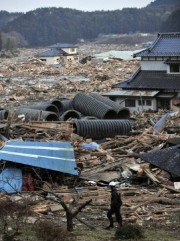 <p>Спасителен работник търси оцелели в руините на град Минами-Синарику. Снимка: БТА</p>