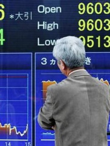 <p>Минувач пред табло с борсови котировки в Токио. <i>Снимка: Ройтерс</i></p>