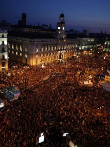 <p style="margin-bottom: 0cm">
	Протестиращите напълниха площад Пуерта дел Сол в Мадрид.<em> Снимка: Ройтерс</em></p>
