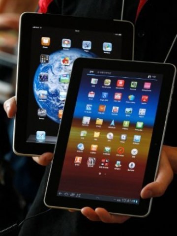 <p>
	Служител на корейския оператор KT позира с Galaxy Tab 10.1 (отпред) и iPad на Apple.&nbsp;<em>Снимка: Ройтерс&nbsp;</em></p>
