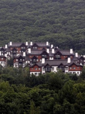 <p style="margin-bottom: 0cm;">
	<span lang="bg-BG">Имоти в ски курорт в близост до избрания за домакин на игрите град Пьончан. <em>Снимка: Ройтерс</em></span></p>
