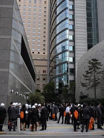 <p>Офис служители в Токио, излезли навън след земетресението на 11 март. <i>Снимка: БТА</i></p>