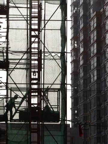 <p>
	Строителни дейности в близост до жилищен блок в Пекин. <em>Снимка: Ройтерс</em></p>
