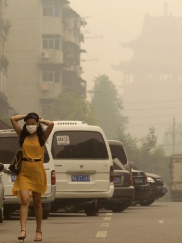 <p>
	Млада китайка се опитва да се спаси от замърсения въздух с маска за лице.&nbsp;<em>Снимка: Ройтерс</em></p>
