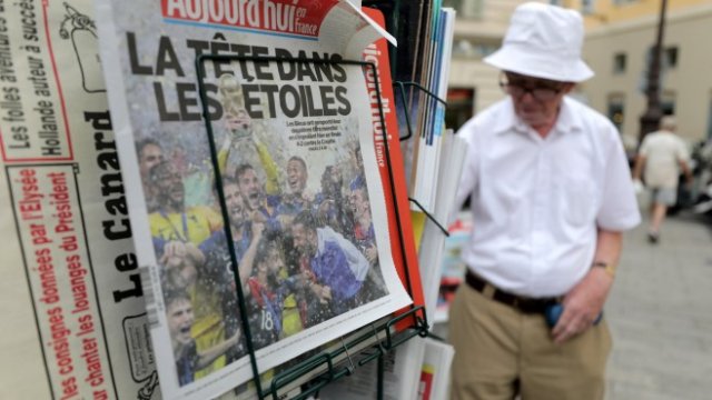 <p>
	Пенсионер купува преса, отразяваща победата на Франция, от магазин в Ница. Снимка: Ройтерс</p>
