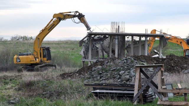 <p>
	<em>Багери на строителя и на ДНСК събарят сградите в комплекса &nbsp; Снимка: БТА</em></p>
