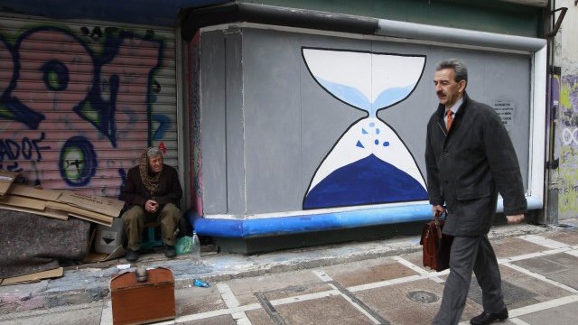 <p>
	<em>Ваксаджия седи пред затворен магазин в Атина. Дълбоката рецесия, обхванала Гърция, заплашва да превърне сделката за дълга в краткотрайно помилване. Снимка: Ройтерс</em></p>
