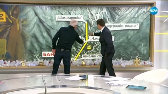 <p>
	Иван Обрейков (л) показва на водещия Виктор Николаев трасето на сегашния лифт (в черно) и на планирания втори лифт (в жълто). <em>Източник: Нова телевизия</em></p>
