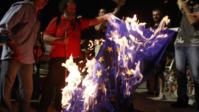 <p>
	Протестиращи гърци горят знамето на ЕС в Солун. <em>Снимка: Ройтерс</em></p>

