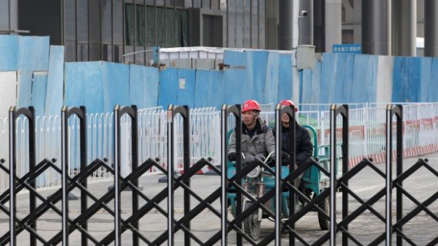 <p>
	Строителни работници в центъра на Пекин. <em>Снимка: Ройтерс</em></p>
