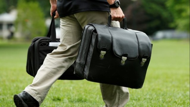 <p>
	<em>Служител на Белия дом носи куфар с кодовете за ядрените оръжия на САЩ. Снимка: Архив Ройтерс</em></p>
