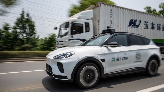 Оборудвано с автономна технология роботакси на Baidu задминава камион на обществен път в провинция Ухан, Китай. Снимка: Bloomberg L.P.