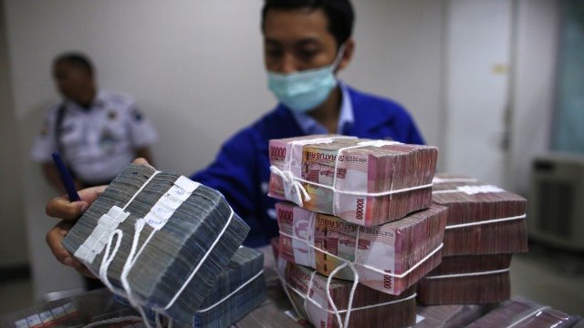 <p>
	Служител в Централната банка на Индонезия пренася банкноти. <em>Снимка: Ройтерс</em></p>
