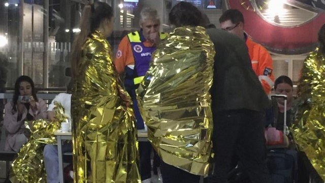 <p>
	Пътници от влака Париж - Лондон, увити в термо одеяла, стоят на гарата в Кале. Влакът беше принуден да се върне обратно в Париж. <em>Снимка: Ройтерс</em></p>
