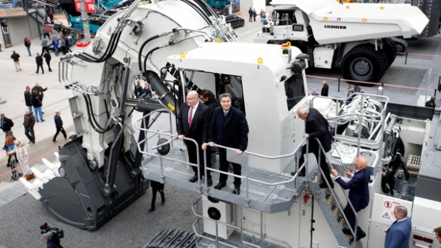 <p>
	Германският министър на икономиката Петер Алтмайер и Маркус Зьодер, министър-председател на Бавария, разглеждат багер R9200 на Liebherr по време на официалната обиколка на търговския панаир за строителни машини Bauma в Мюнхен, Германия. <em>Снимка: Ройтерс</em></p>
