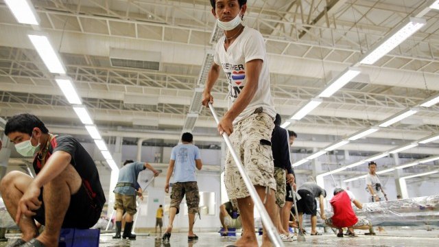 <p>
	Служители на Hana Microelectronics почистват производствените халета след отдръпването на водата. Снимка: Ройтерс</p>
