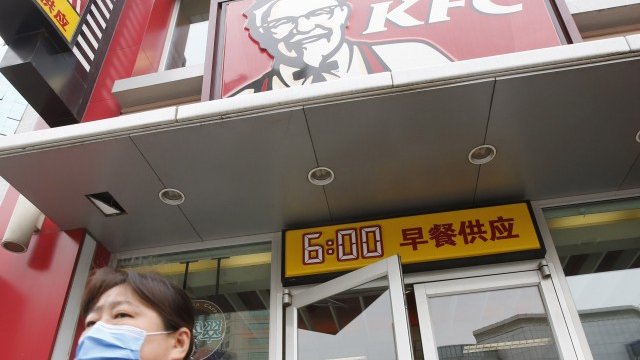 <p>
	Жена минава покрай KFC в Пекин с маска заради скандалите с некачествена храна.&nbsp;<em>Снимка: Ройтерс</em></p>
