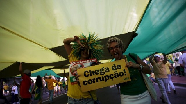 <p>
	Демонстранти носят надписи: Стига корпуция! <em>Снимка: Ройтерс</em></p>
