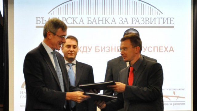 <p>
	Ричард Пели и Андрей Генев разменят папките с току-що подписаното споразумение пред погледа на Асен Ягодин. <em>Снимка:&nbsp;Prime Time PR Agency</em></p>

