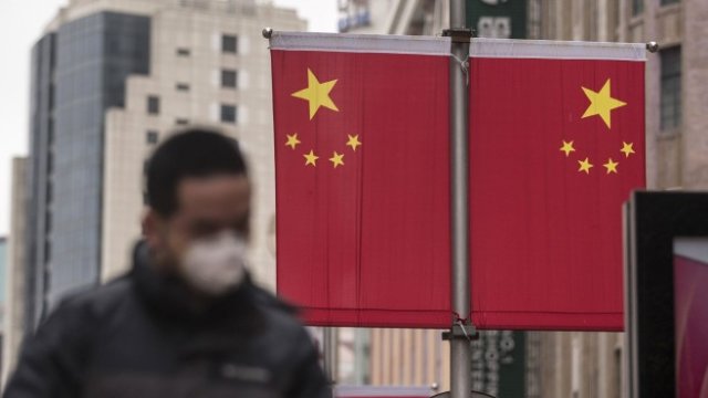 <p>
	Пешеходец с маска по улиците на Шанхай. <em>Снимка: Qilai Shen/Bloomberg</em></p>
