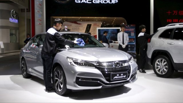 <p>
	Служител почиства седана Аccord на марката Honda на щанда на Guangzhou Automobile Group по време на автомобилното изложение Auto China 2016 в Пекин, Китай. <em>Снимка: Архив Ройтерс</em></p>
