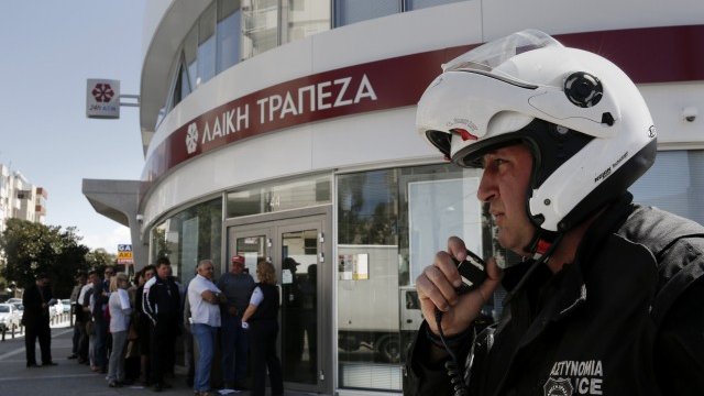 <p>
	Пред банките в Кипър днес има засилено полицейско присъствие. <em>Снимка: Ройтерс</em></p>
