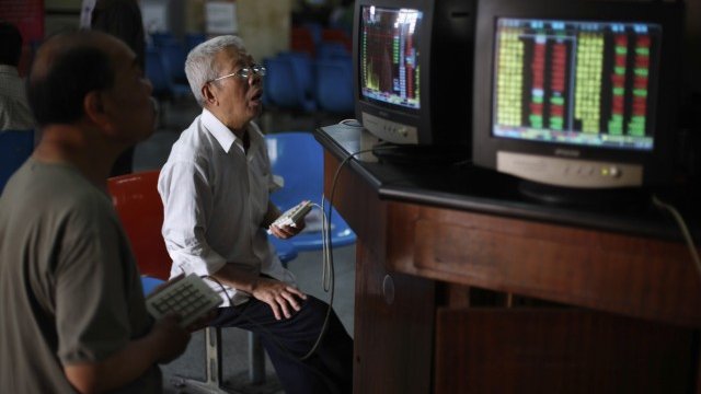 <p>
	Инвеститори следят курсовете на борсата в Шанхай. <em>Снимка: Ройтерс</em></p>
