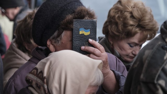 Жителка на освободения град Лиман целува украинския си паспорт. Снимка: ЕРА