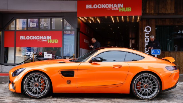 Мотото &bdquo;In Crypto We Trust&ldquo; може да се види на гумата на луксозен автомобил Mercedes-Benz, паркиран пред павилион на Blockchain Hub. Снимка: Stefan Wermuth/Bloomberg
