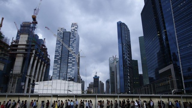 <p>
	Офис служители на път за работа в Сингапур. <em>Снимка: Ройтерс</em></p>
