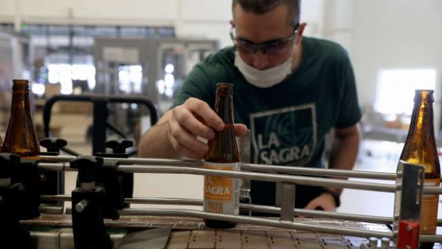 <p>
	Служител проверява бутилка в завод за крафт бира в Нумансия де ла Сагра до Мадрид. <em>Снимка: Ройтерс</em></p>
